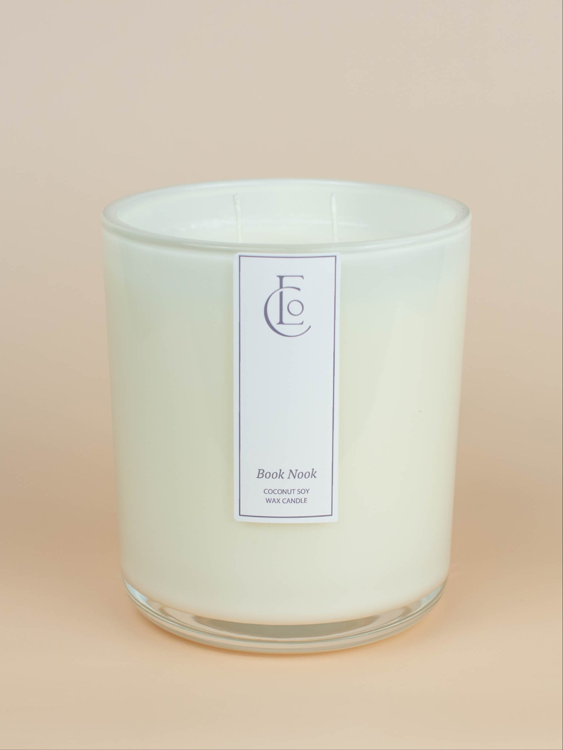 Glass candle with a cream label on a beige background